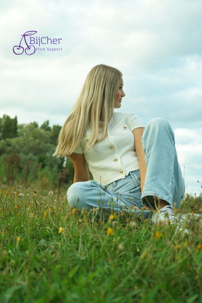 blonde dame zittend in het gras zij aanzicht branding fotografie