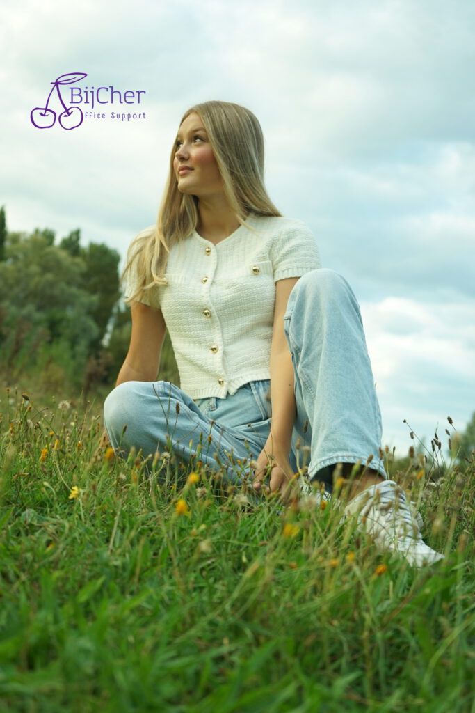 foto van een jonge dame in het gras in de avond zon